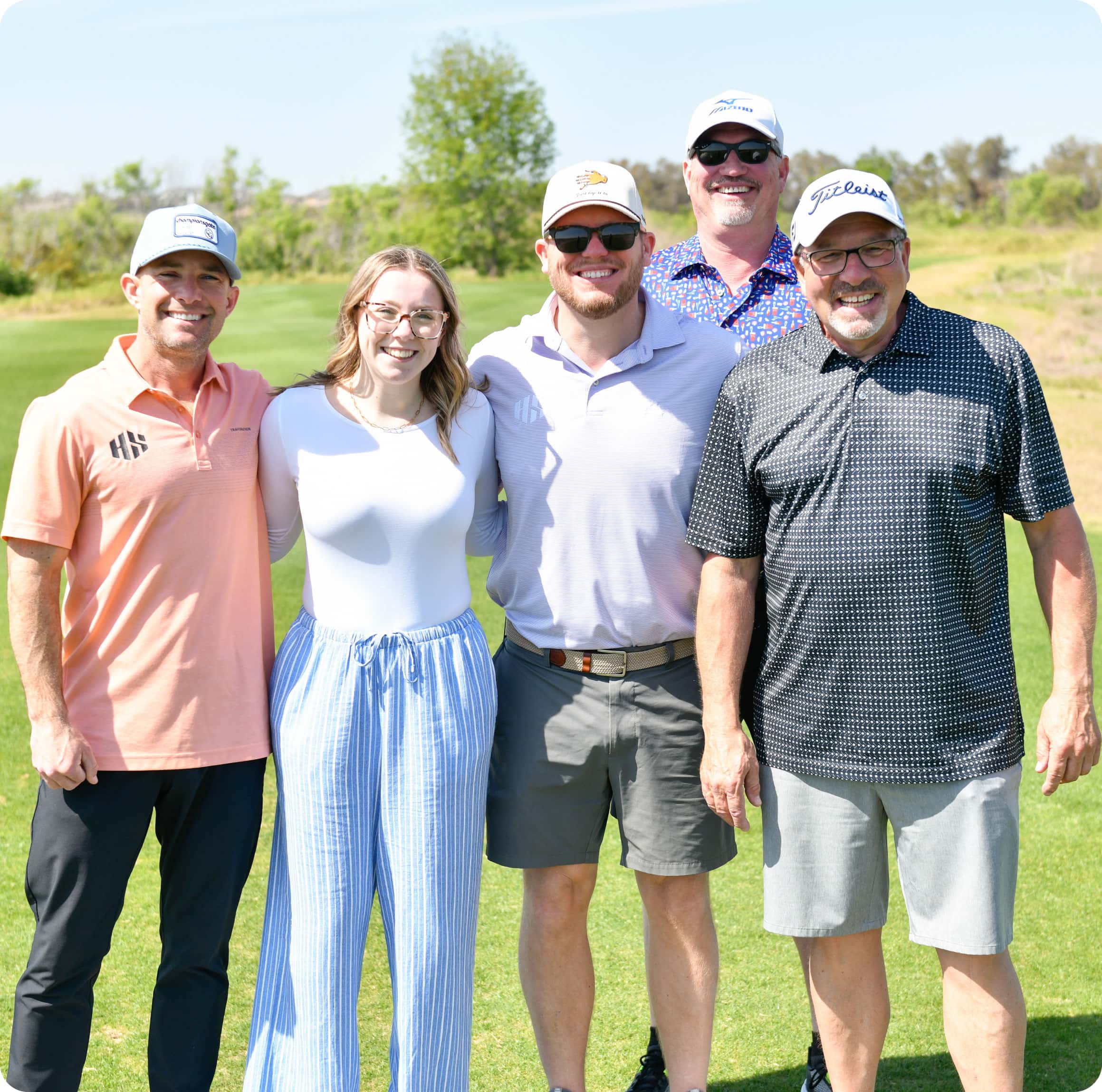 Group of smiling golfers standing with an educational scholarship recipient